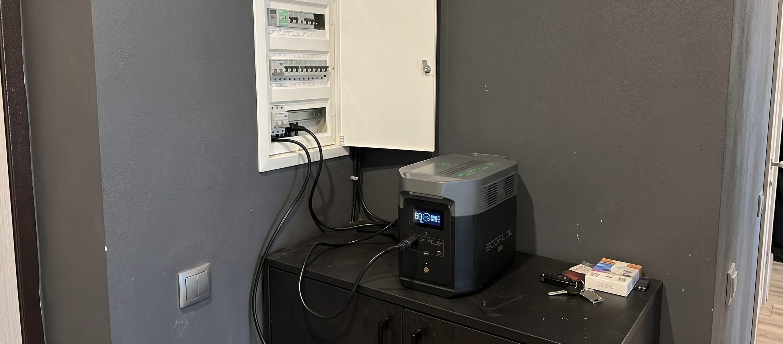 An electrician's hand with a screwdriver next to circuit breakers on a DIN rail